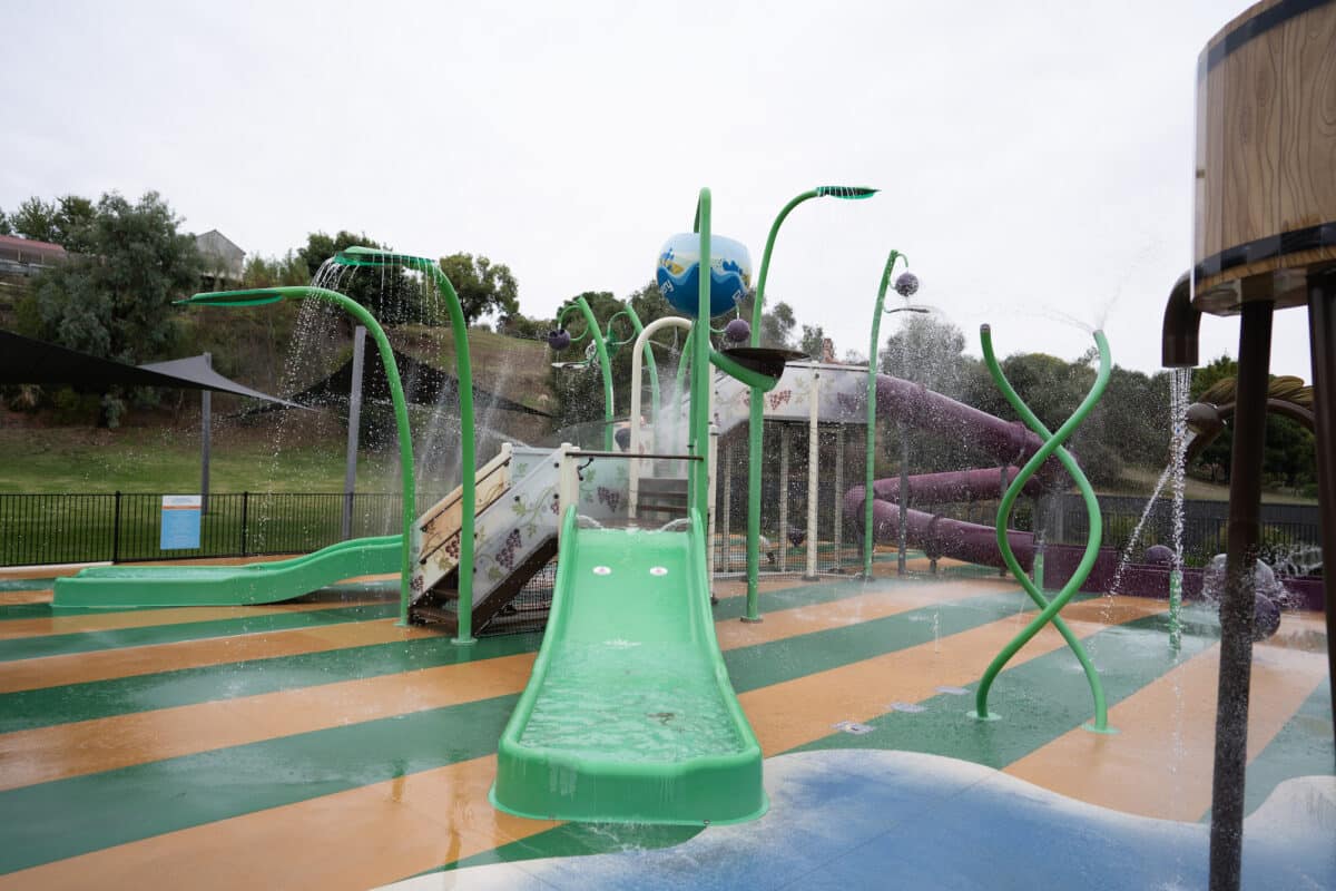 Splash Park with green water slides and timed blue water bucket on a green and yellow play surface Discovery Parks - Barossa Valley BBQ
