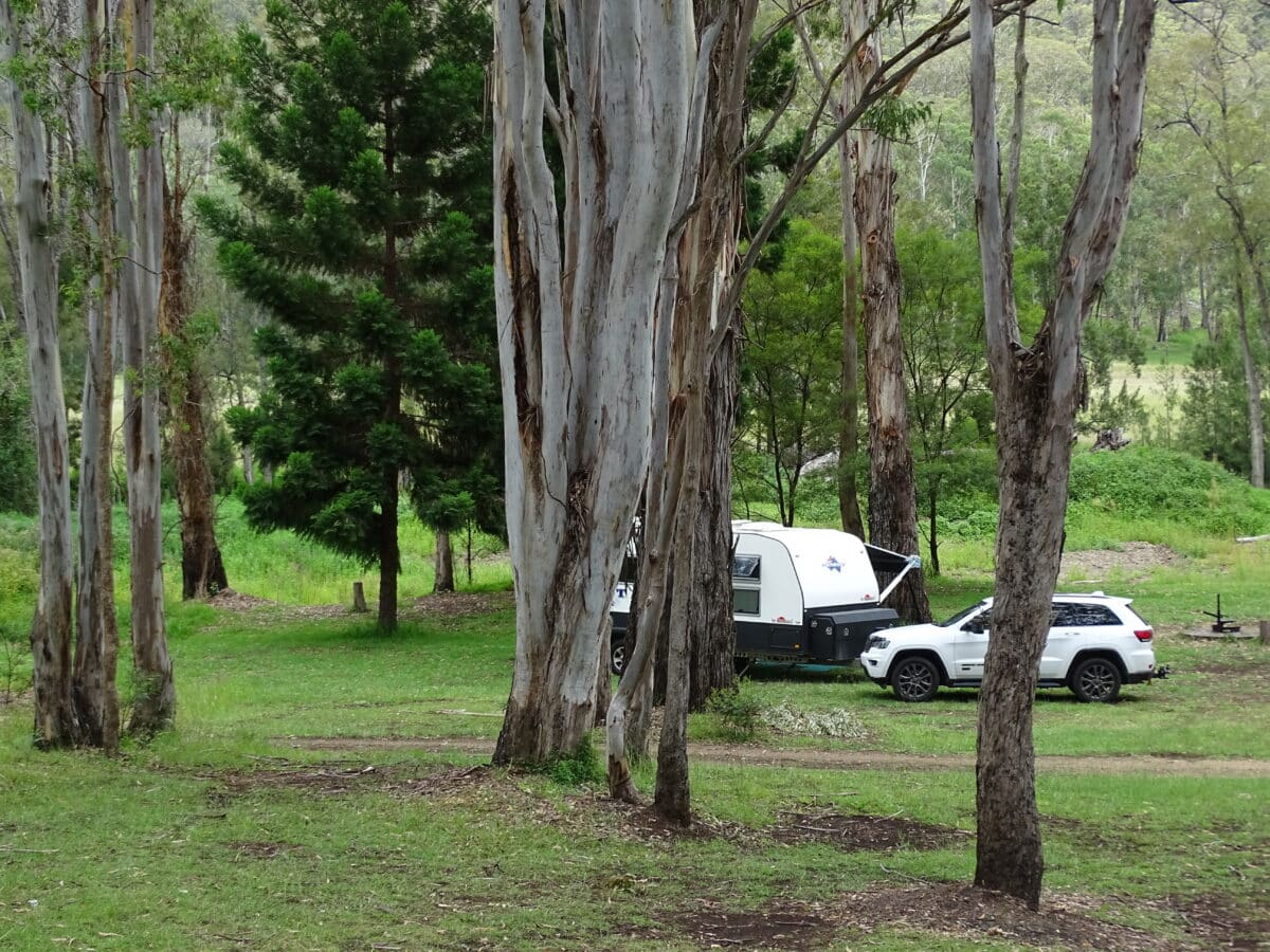 A caravan parked under shade. Access to this campsite is over the Dalrymple Creek.
