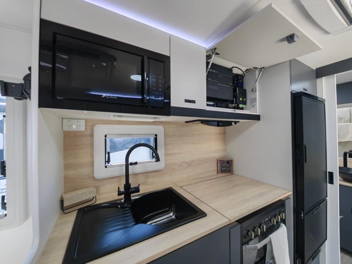 Caravan interior, featuring oak coloured splashback, inbuilt microwave, 