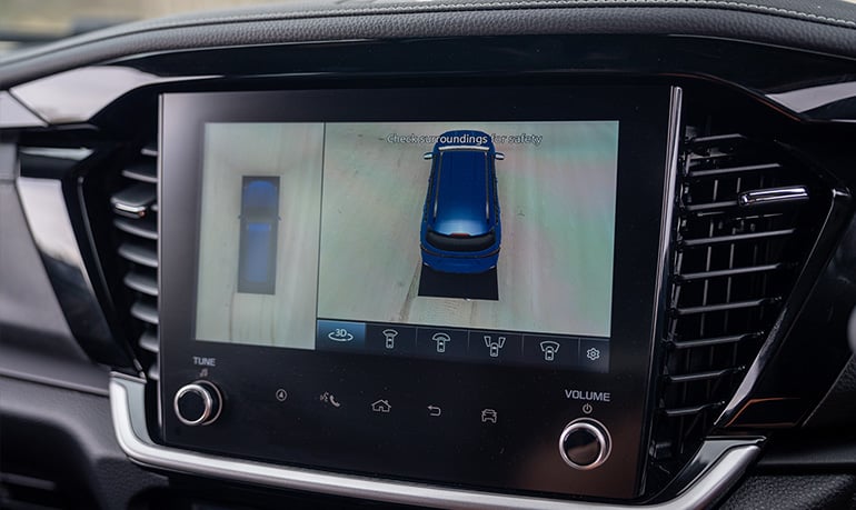 he 9-inch infotainment screen The inside the Isuzu MU-X displaying the 360-degree camera's top-down view, which aids visibility when hitching or maneuvering a caravan.