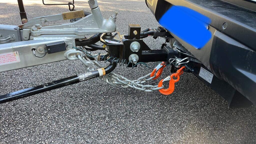 The Austlift Safety Chain Hook shown attached to a vehicle with weight distribution bars