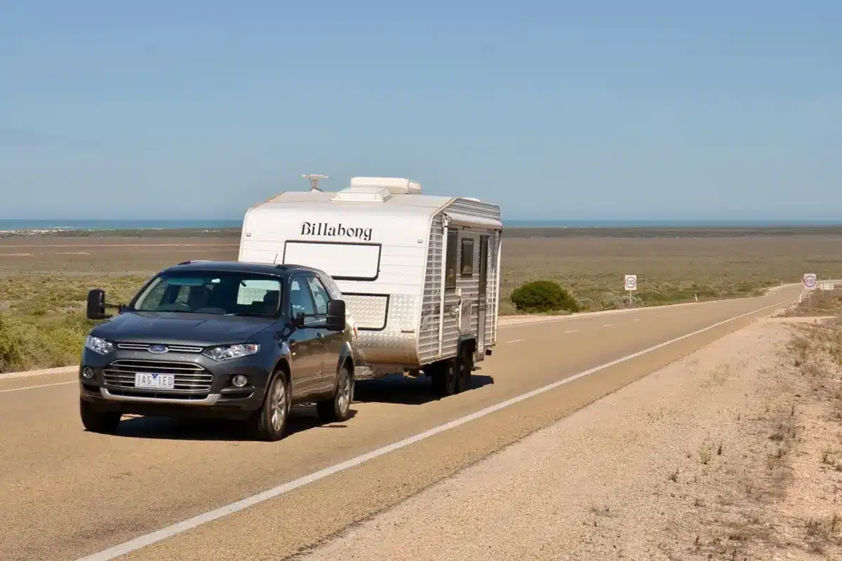 Caravan being towed along Australian highway during long-distance road trip