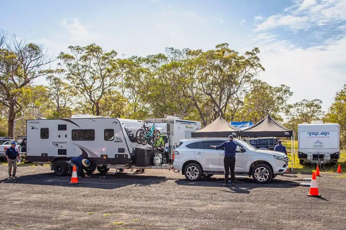 Caravan and tow vehicle being weighed at mobile inspection site in Australia