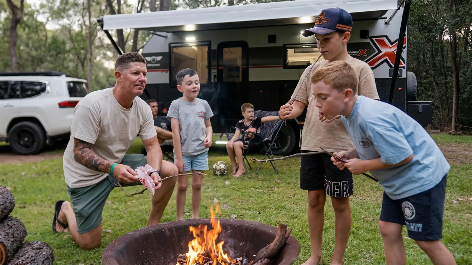 Children toasting marshmallows over a campfire at a caravan holiday park campsite