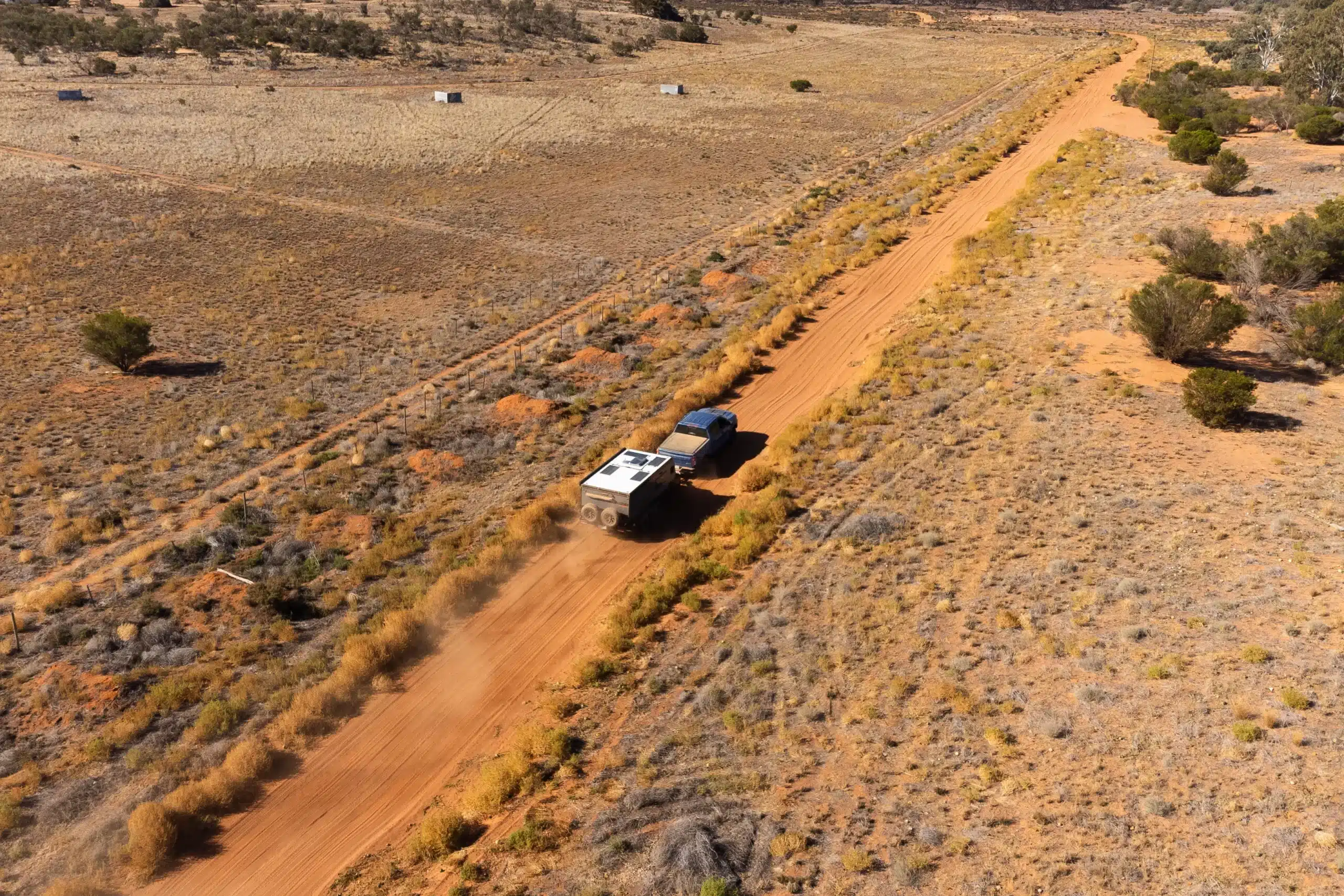 Caravan travelling on dusty outback road where dust reduction systems help keep interiors clean