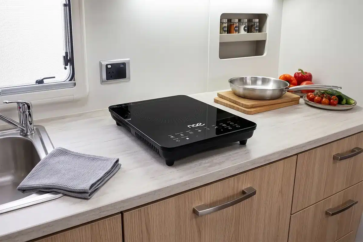 nce portable induction cooktop with fresh vegetables in caravan